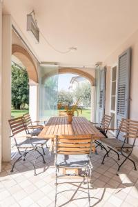 a patio with a wooden table and chairs at Villa La Corte in Cesa