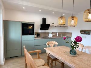 a kitchen and dining room with a table and chairs at Gästehaus Passat in Niendorf