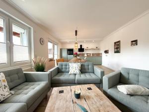 a living room with two couches and a table at Gästehaus Passat in Niendorf
