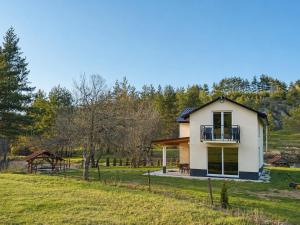 a small white house with a balcony on a field at Villa Marija in Livno