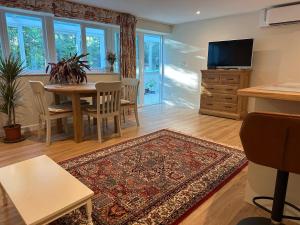 a living room with a table and a tv at Hornbeams Annexe - Deluxe Apartment in Biddenden