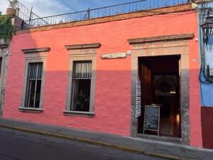 a red and orange building on a city street at Navarrete 63 Hotel in Morelia +3 photos