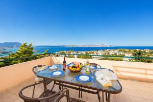 a table with a bowl of fruit on a balcony at Ariadne Villa in Plaka