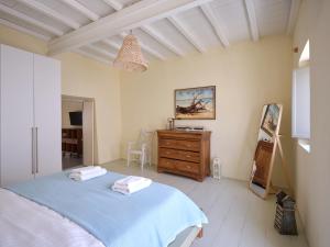 a bedroom with a blue bed and a wooden dresser at Flair Naousa in Naousa