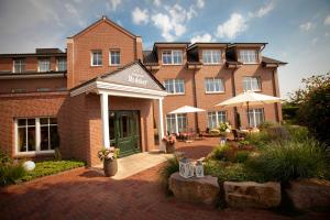 a large brick building with a patio in front of it at Landgasthof Redeker in Haselünne