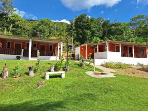 a house with a green yard in front of it at Hospedagem Horizonte Azul- Recanto São Thomé in Eldorado