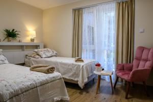 a bedroom with two beds and a window at Apartamenty 40 in Ciechocinek