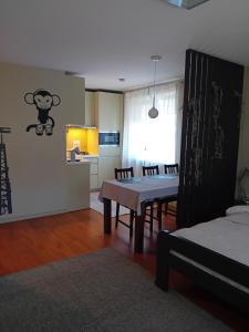 a living room with a table and a kitchen at Grīvas apartamenti in Ogre