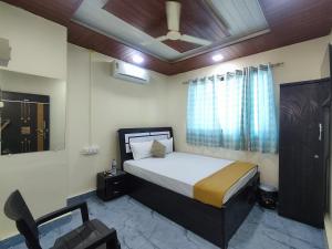a bedroom with a bed and a chair in it at Ambient Homestay NESTEASY in Nashik