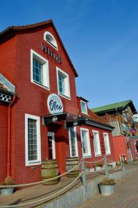 a red brick building with a sign on it at Restaurant Ollex and beds Zimmer 4 in Bliesdorf
