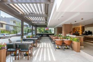 a restaurant with tables and chairs and windows at The Marni Hotel & Spa - Adults Only 12 Plus in Antalya
