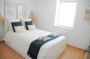 a bedroom with a white bed with towels on it at À 8min du parc LE PAL Le cocon de Kenna in Dompierre-sur-Besbre +23 photos