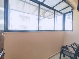 a large window in a room with a chair at Ambient Homestay NESTEASY in Nashik