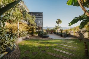 a garden with a walkway and a building at Pousada Boutique Villa Valley in Praia do Rosa