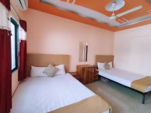 a bedroom with two beds and a window at Ambient Homestay NESTEASY in Nashik