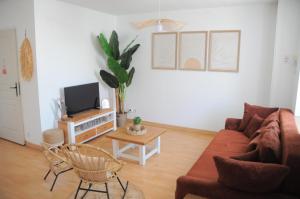 a living room with a couch and a tv at À 8min du parc LE PAL Le cocon de Kenna in Dompierre-sur-Besbre