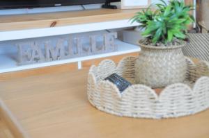 a potted plant in a basket on a table at À 8min du parc LE PAL Le cocon de Kenna in Dompierre-sur-Besbre