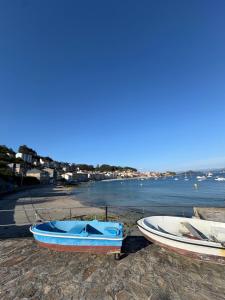 two boats sitting on the shore of a body of water at El paraíso I in Raxó