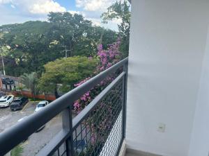 a balcony with a plant with purple flowers at Flat Studio Charmoso New Studio Granja Viana Cotia Sao Camillo 642 in Carapicuíba