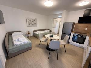 a small room with two beds and a table and a kitchen at Apartments Puntamika in Zadar