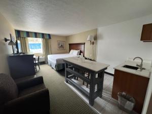 a hotel room with a bed and a table and a kitchen at The Boardwalk Inn in Branson