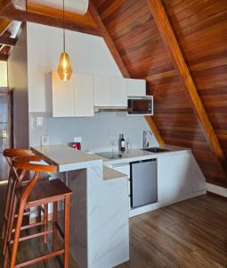 a kitchen with white appliances and wooden ceilings at Riosol Laguna Azul in Sauce