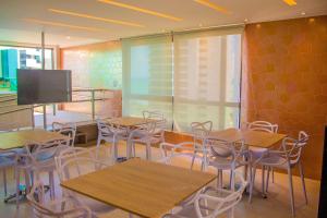 a classroom with tables and chairs and a flat screen tv at Freitas Residence - Quinta Manuel Rodrigues in Recife