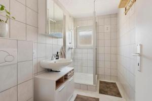 a white bathroom with a sink and a shower at Four Seasons in Krautheim +12 photos