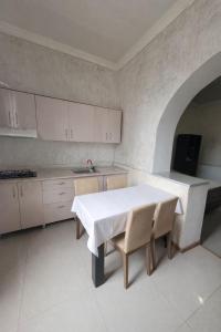 a kitchen with a white table and chairs in it at У Царицы in Kobuleti