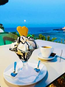 a table with a ice cream sundae and a cup of coffee at Hidden Gem Playa Flamenca Apartment with Pool View - Oleza Garden in Playa Flamenca