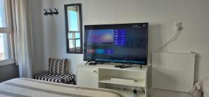a bedroom with a large flat screen tv on a white cabinet at Monoambiente Manquel in Necochea
