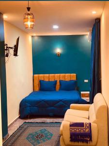 a bedroom with a blue bed and a couch at Ali City Hotel tunis in Tunis