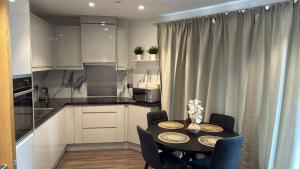 a kitchen with a table and chairs and a kitchen with white cabinets at Malijeed Services limited in London