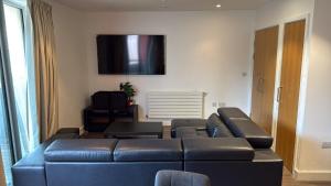 a living room with a blue couch and a flat screen tv at Malijeed Services limited in London
