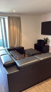 a living room with a couch and a flat screen tv at Malijeed Services limited in London