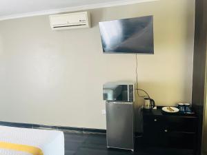 a room with a small refrigerator and a microwave at Shiloh Tlokweng in Gaborone