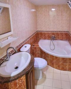 a bathroom with a tub and a toilet and a sink at Ali City Hotel tunis in Tunis