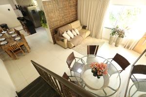 a living room with a glass table and chairs at Pousada House Garden in Goiânia