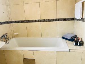 a white bath tub in a bathroom next to a sink at Shiloh Tlokweng in Gaborone