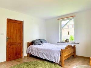 a bedroom with a bed and a window at Przytulna Chata in Zamiany