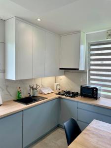 a kitchen with white cabinets and a counter top at Przytulna Chata in Zamiany