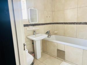 a bathroom with a sink and a bath tub at Shiloh Tlokweng in Gaborone
