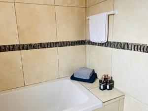 a bathroom with a white tub and a sink at Shiloh Tlokweng in Gaborone