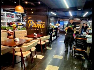 a man with a stroller walking through a restaurant at Premier Residence in Brasília