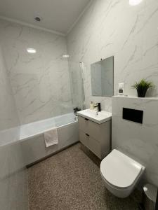 a bathroom with a toilet and a sink and a tub at Apartament w Sosnowym SPA in Serock +80 photos