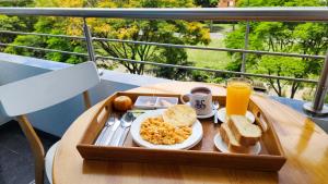 a tray of breakfast food on a table on a balcony at BE Suites Hotel Cali in Cali