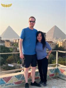 a man and a woman standing in front of pyramids at Zak Pyramids Inn in Cairo