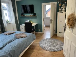 a bedroom with a bed and a desk and a tv at OESLAUER STUBE Gemütliches Apartment mit Kamin, Klimaanlage, Balkon, 3 Schlafzimmern, 2 Bädern, Modern, Familienfreundlich, Zentral, Vollausgestattet in Rödental
