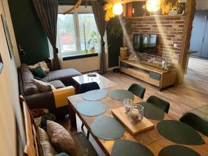 a living room with a table and a couch at OESLAUER STUBE Gemütliches Apartment mit Kamin, Klimaanlage, Balkon, 3 Schlafzimmern, 2 Bädern, Modern, Familienfreundlich, Zentral, Vollausgestattet in Rödental