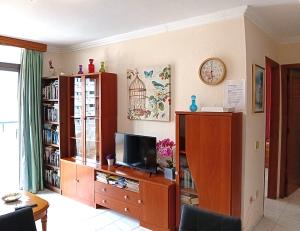 a living room with a tv on a wooden entertainment center at Summerland LC Holiday Home in Los Cristianos